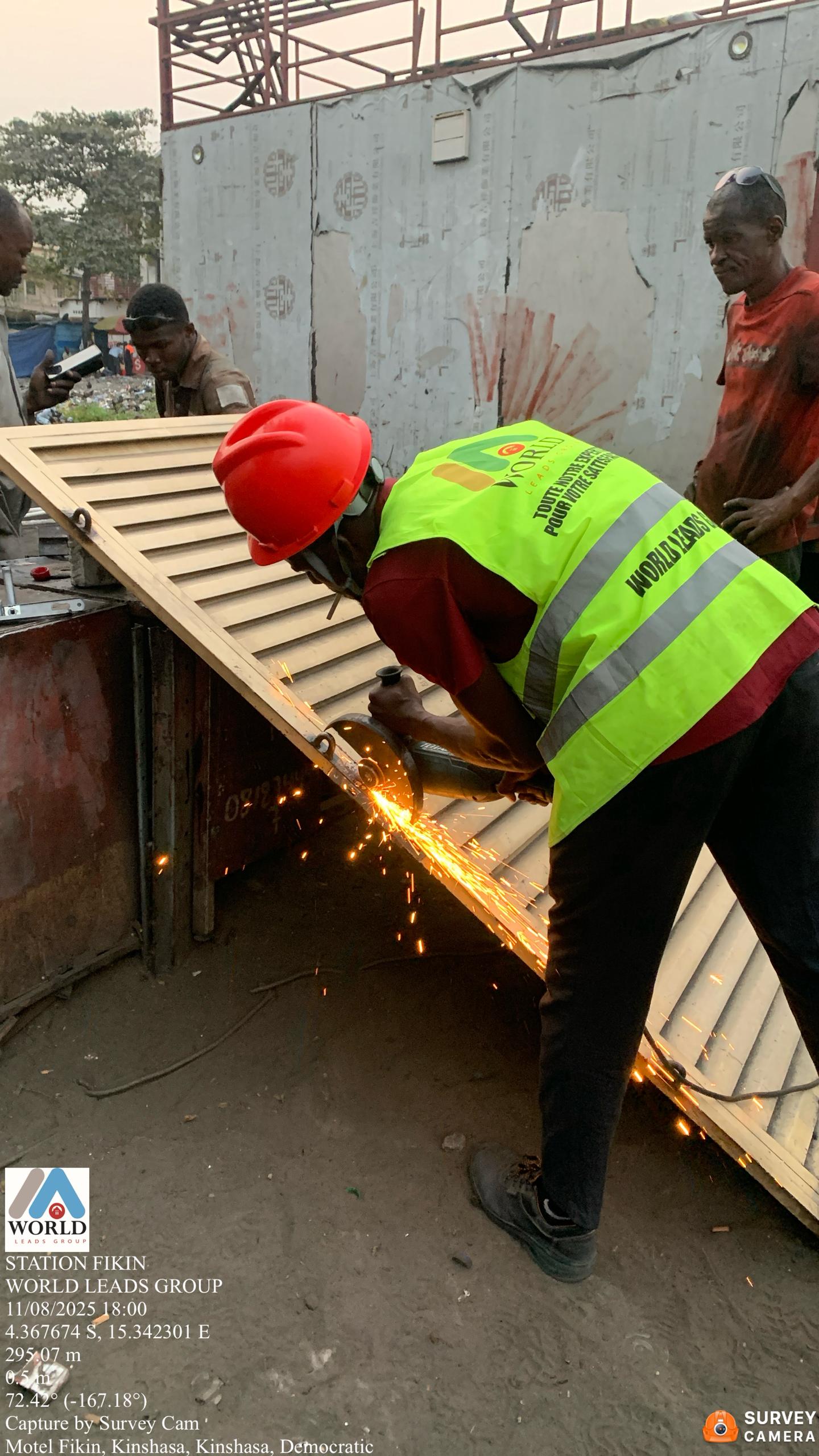 Pendant les travaux - Installation de la serrure sur la porte métallique à la Station-service Fikin